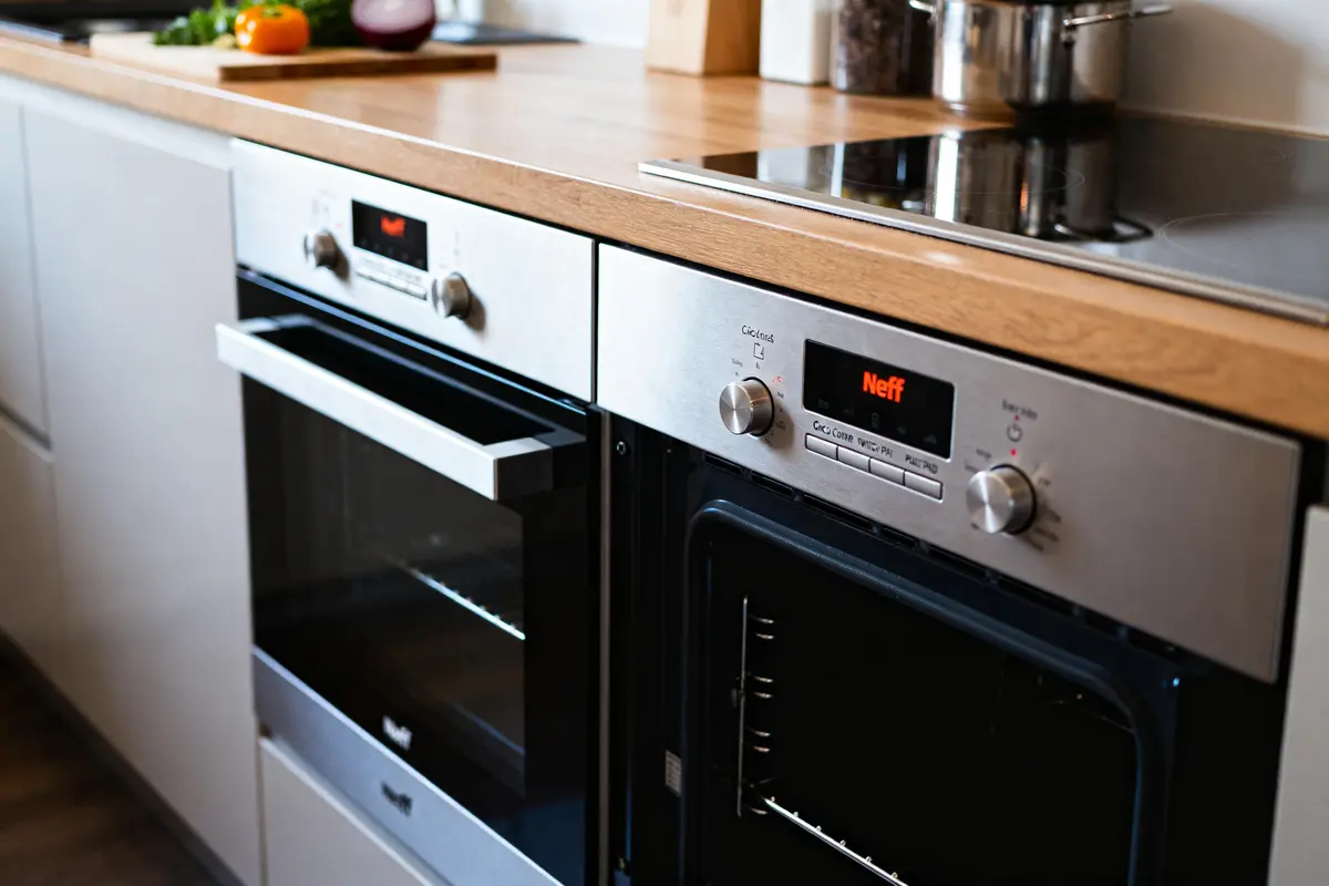Cuisine moderne avec doubles fours encastrés de marque Neff's et plan de travail en bois
